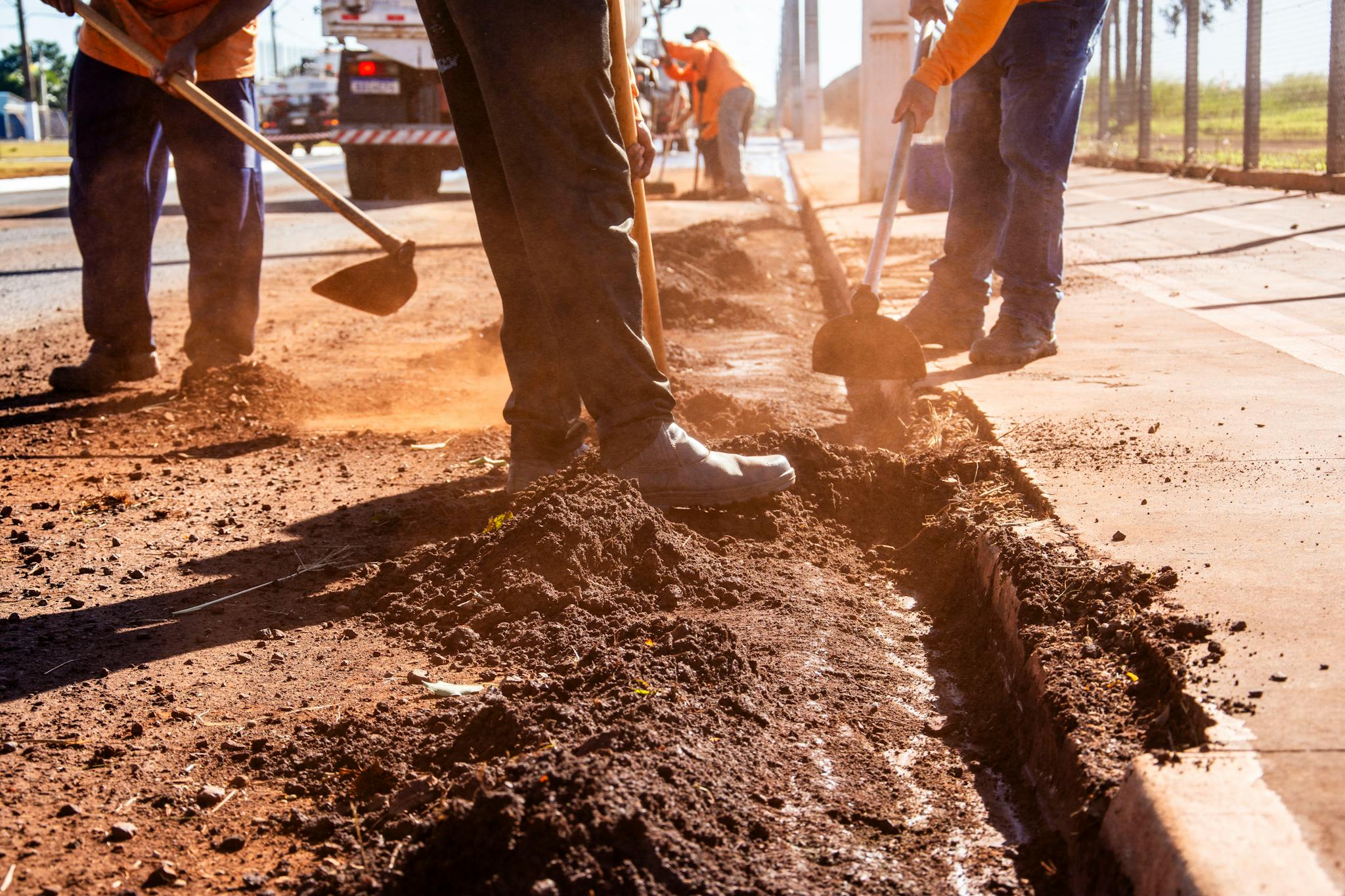 Road maintenance workers using tools in Londrina, Brazil streets.